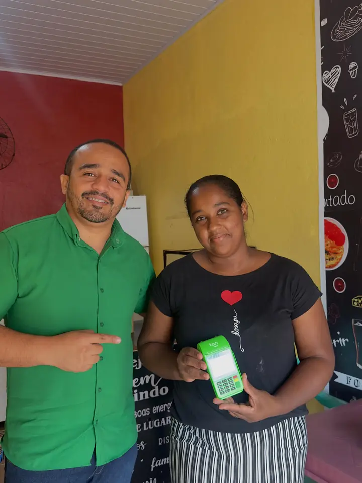 Bruno e uma comerciante segurando uma maquininha Ton